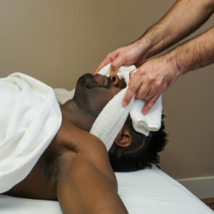 Male receives a deep tissue massage for his upper neck at Whole Being Massage in Boise, ID