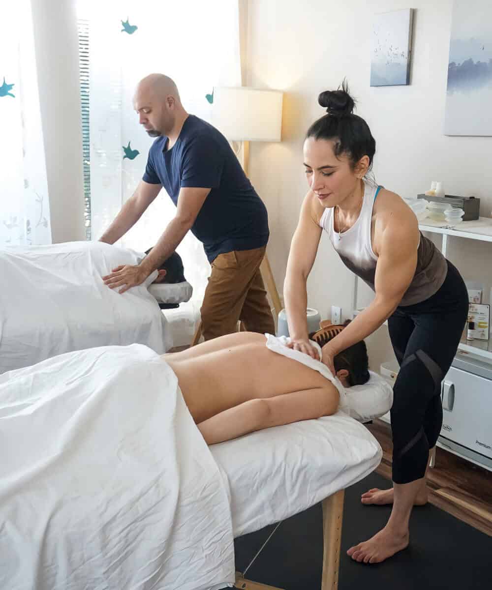 A couple enjoys a side-by-side couples massage at Whole Being Massage