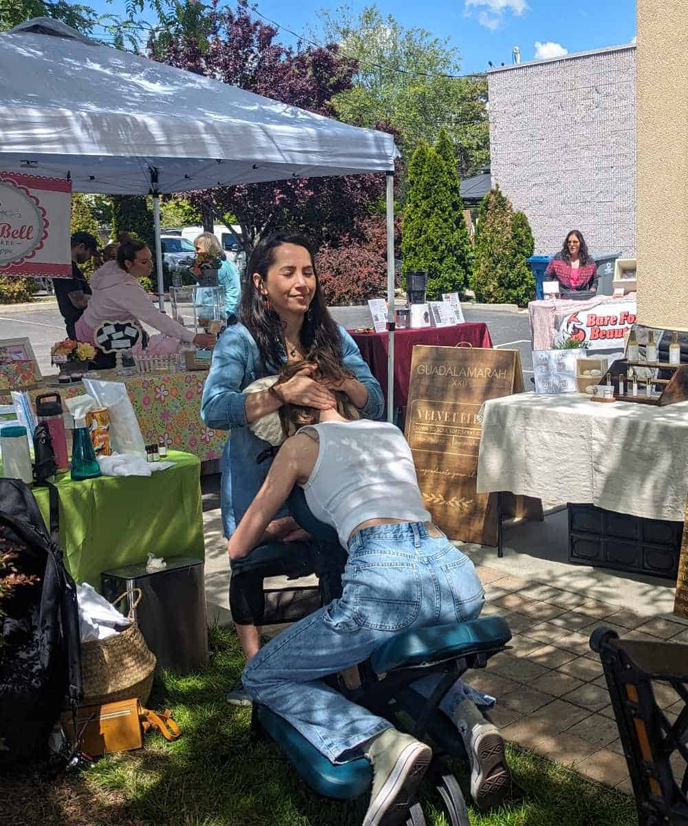 Gwen offers complimentary chair massage and lymph drainage therapy to wellness networking event attendee.