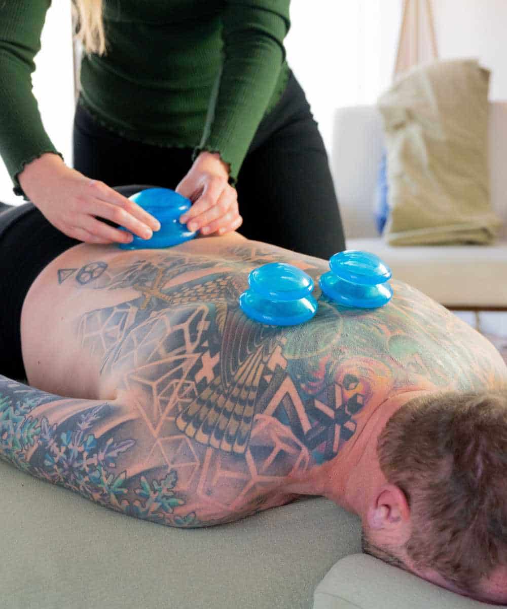 Sports massage therapist applies cupping during treatment at Whole Massage in Boise, ID